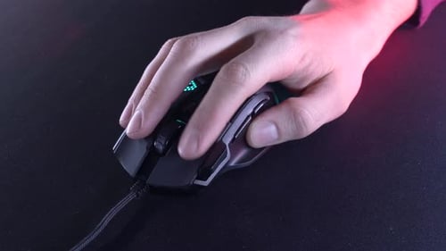 Hand Clicking Black Gaming Mouse on Dark Mat