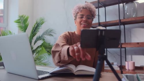 Smiling Woman Recording Video Tutorial at Desk