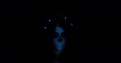 Woman in Skull Makeup in the Dark