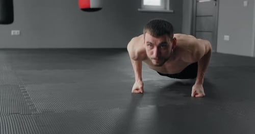 Athlete Performs Fast Pushups on His Fists at the Gym Camera Follows the Movement Workout Training