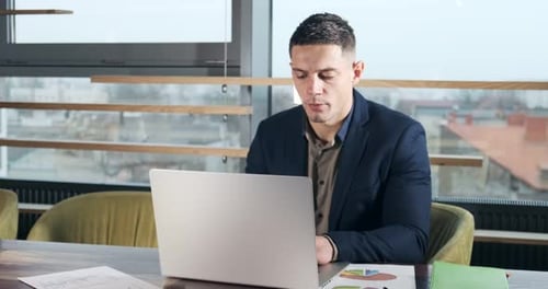 Besorgter Mann arbeitet am Laptop und schaut weg und denkt daran, Probleme im Büro zu lösen