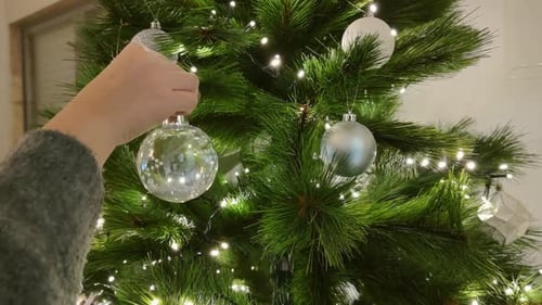 Decorating Christmas Tree with Ornaments and Lights