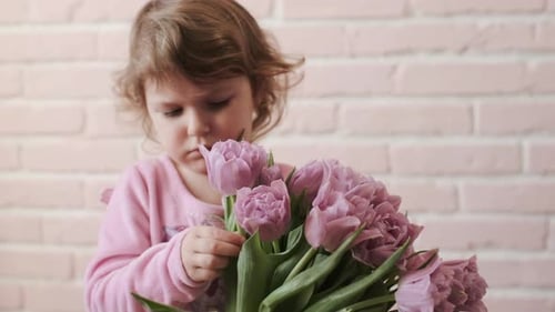 Portrait Of A Kid With A Bouquet Of Flowers In His Hands. Sadness. Close-up.