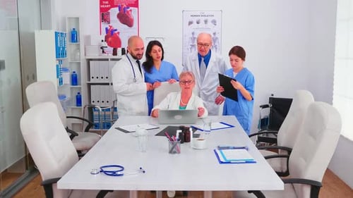 Medical Team Discussing Patient Data on Laptop