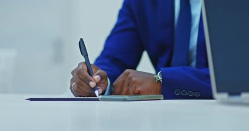 Adult Writing at Desk in an Office Setting