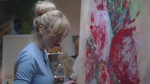 Woman Painting an Abstract Image on Canvas Indoors