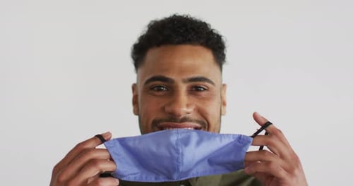 Young Adult Putting on Blue Protective Face Mask