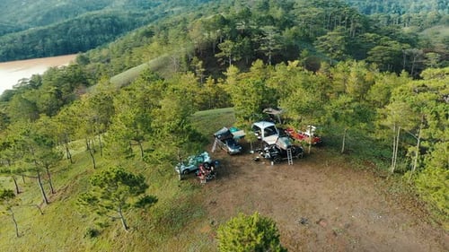 Aerial view of Mountainside Camping Adventure with Off-Road Vehicles