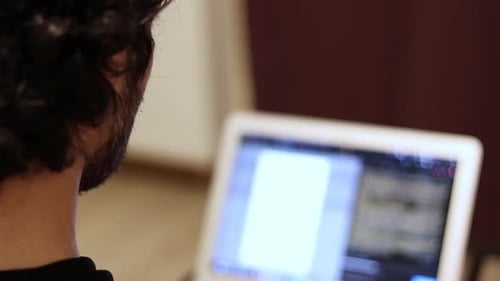 Man close-up coding on laptop with blurry screen. Programming and developing software. IT freelance