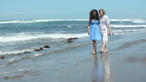 Couple walking together along beach