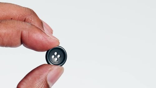 Fingers Holding Black Button