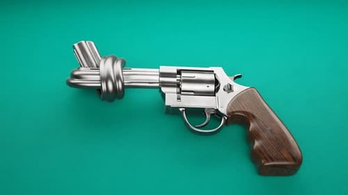 Revólver con un nudo en el cañón. Pistola metálica tendida sobre tela verde