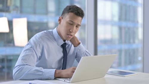 Tired African American Businessman Having Neck Pain in Office