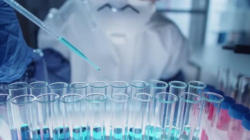 Scientist Adds Liquid to Test Tubes in Laboratory