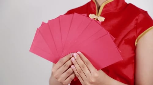 Handhaltender roter Umschlag mit der Aufschrift „Frohes Chinesisches Neues Jahr“