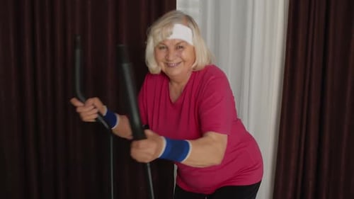 Senior Woman Exercising on Elliptical Machine at Home