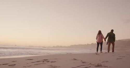 Active senior couple walking on beach
