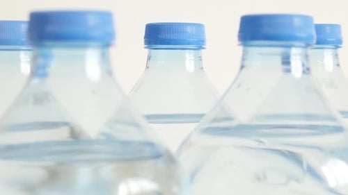Tilting over opened bottled water package close-up 4K 2160p 30fps UltraHD tilting footage - Transpa