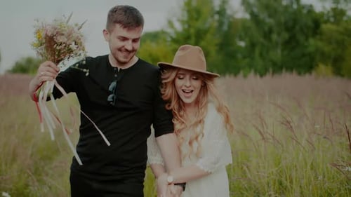 Carefree Couple in Love Walking on a Meadow in Countryside on Holidays