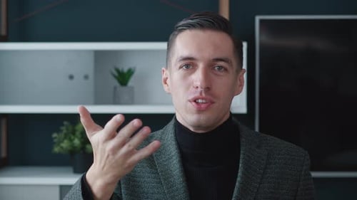 Man in Blazer Talking and Gesturing to Camera