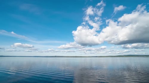 Ruhige Flusslandschaft mit weißen Wolken im strahlend blauen Himmel Zeitraffer