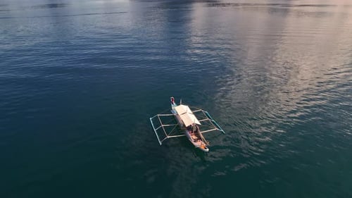 Zumbido sobre el mar iluminado por el sol con mujer en bote estabilizante