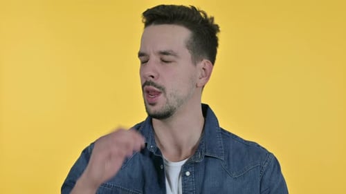 Young Adult Yawning on a Yellow Background