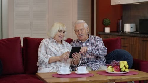 Senior Couple Using Tablet Together on Couch