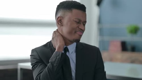 Man Massaging Neck in Office Due To Pain