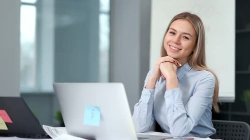 Portrait of Smiling Attractive Young Businesswoman or Office Worker Sitting at Workplace