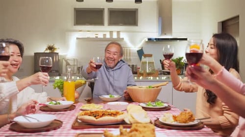 Happy Asian Family Toasting Wine at Dinner