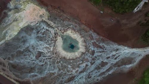 Drohnenflug über Geysir-Pool und umgebende geothermische Landschaft
