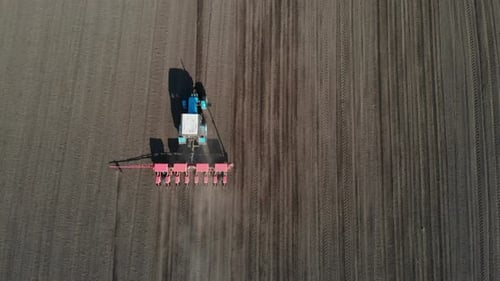 Top view of a tractor fertilizes a field