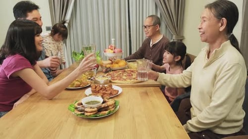 Family Toasting Together at Dinner Table Indoors