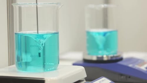 Blue Liquid Mixing in Beakers in Lab