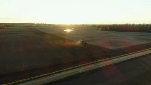Tractor Working in Field at Golden Hour