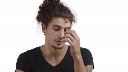 Closeup of Handsome Hispanic Young Man with Beard and Curly Combed Hair Looking Annoyed Facepalm and