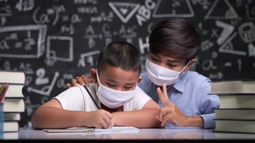 Young Student Being Tutored in a Classroom