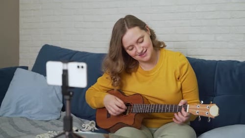 Woman Plays Ukulele and Sings at Home
