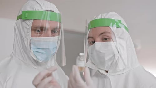 Medical Professionals Examining Vaccine Vial in Laboratory