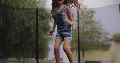 Child Bouncing on a Trampoline Outdoors