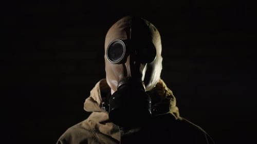 Ein Mann in Schutzanzug und Gasmaske auf schwarzem Hintergrund