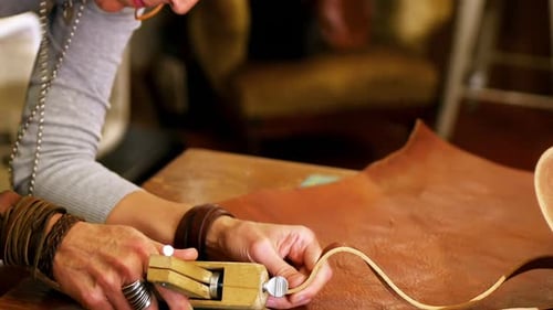 Close-up of craftswoman cutting leather