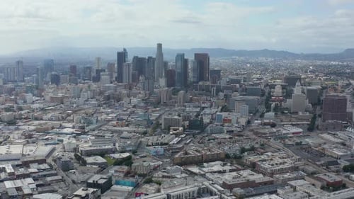 AERIAL: Slowly Circling Downtown Los Angeles Skyline with Warehouse Art District in Foreground