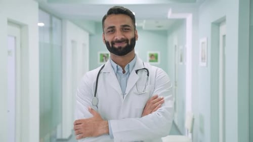 Male Happy Confident Indian Doctor Standing in Clinic Hospital