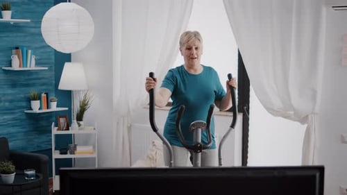 Mature Woman Using Elliptical Machine for Home Workout