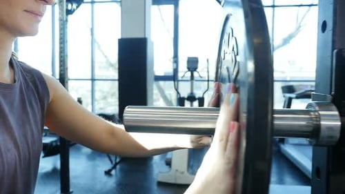 Junge Fitnessfrau bereitet sich auf Gewichtheben vor