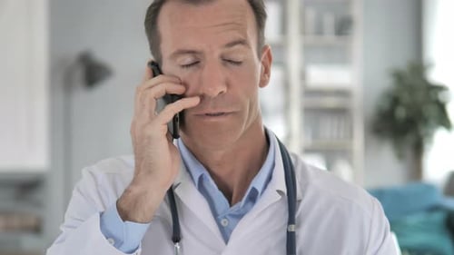 Doctor in White Coat Talking on Smartphone