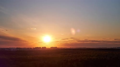Sunset among the evening clouds. Red sun in the evening sky, timelapse