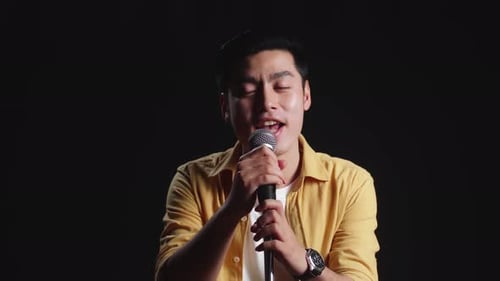 Young Man Singing Passionately Into Microphone